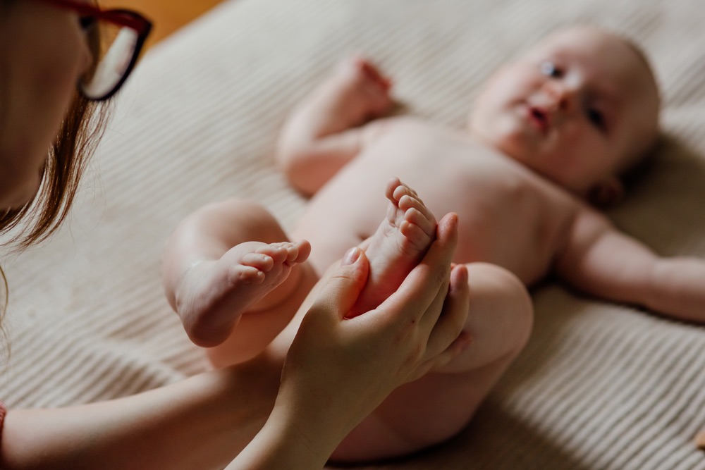 Mutter massiert den Fuß eines Babys